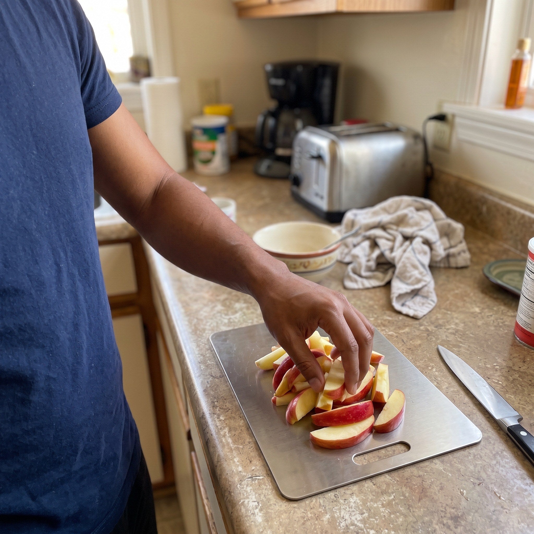 Liam placing sliced apple on his steel board
